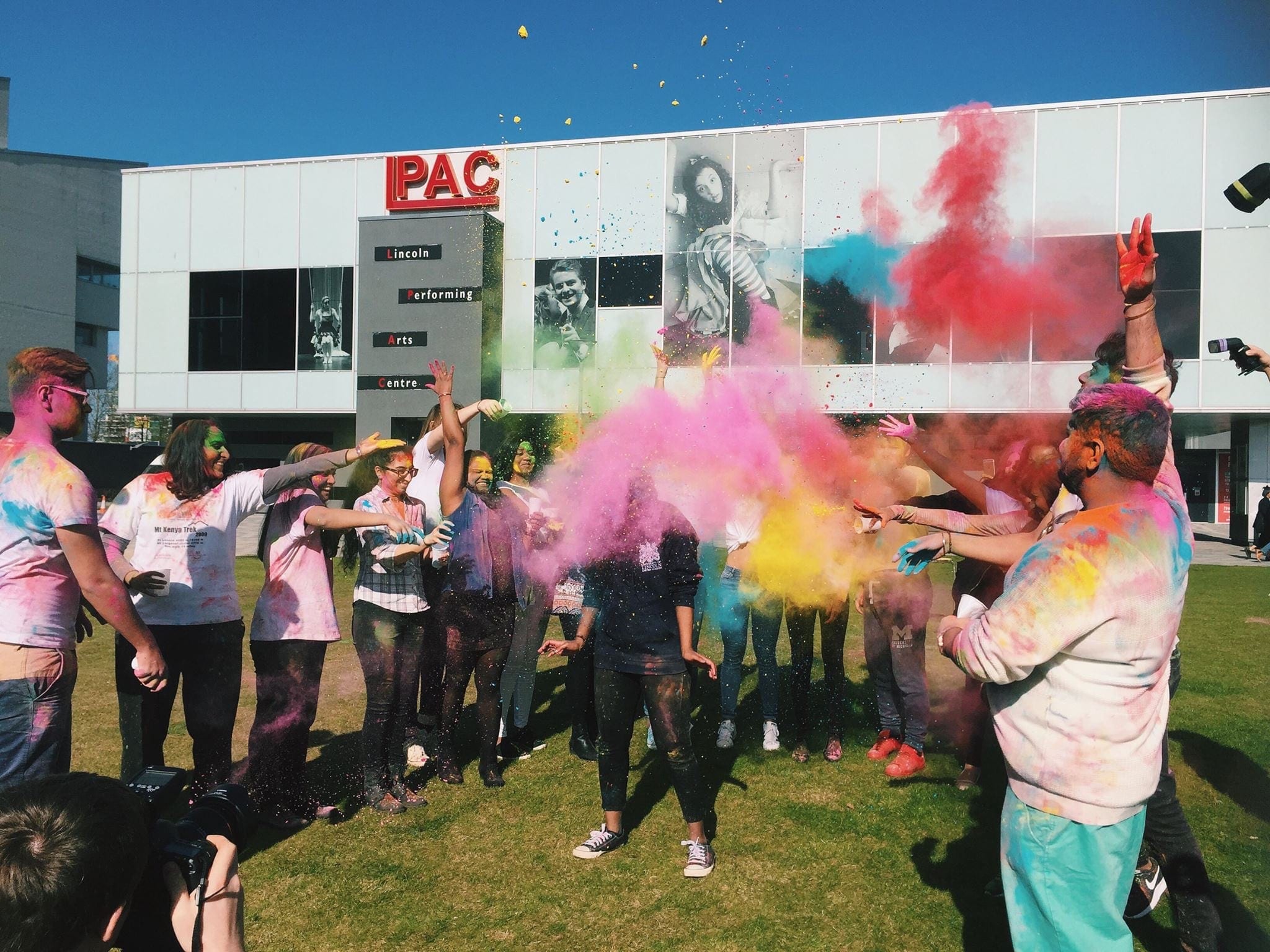 Learning at Lincoln - Group of University of Lincoln students throwing multicoloured paint powder at Holi celebration.